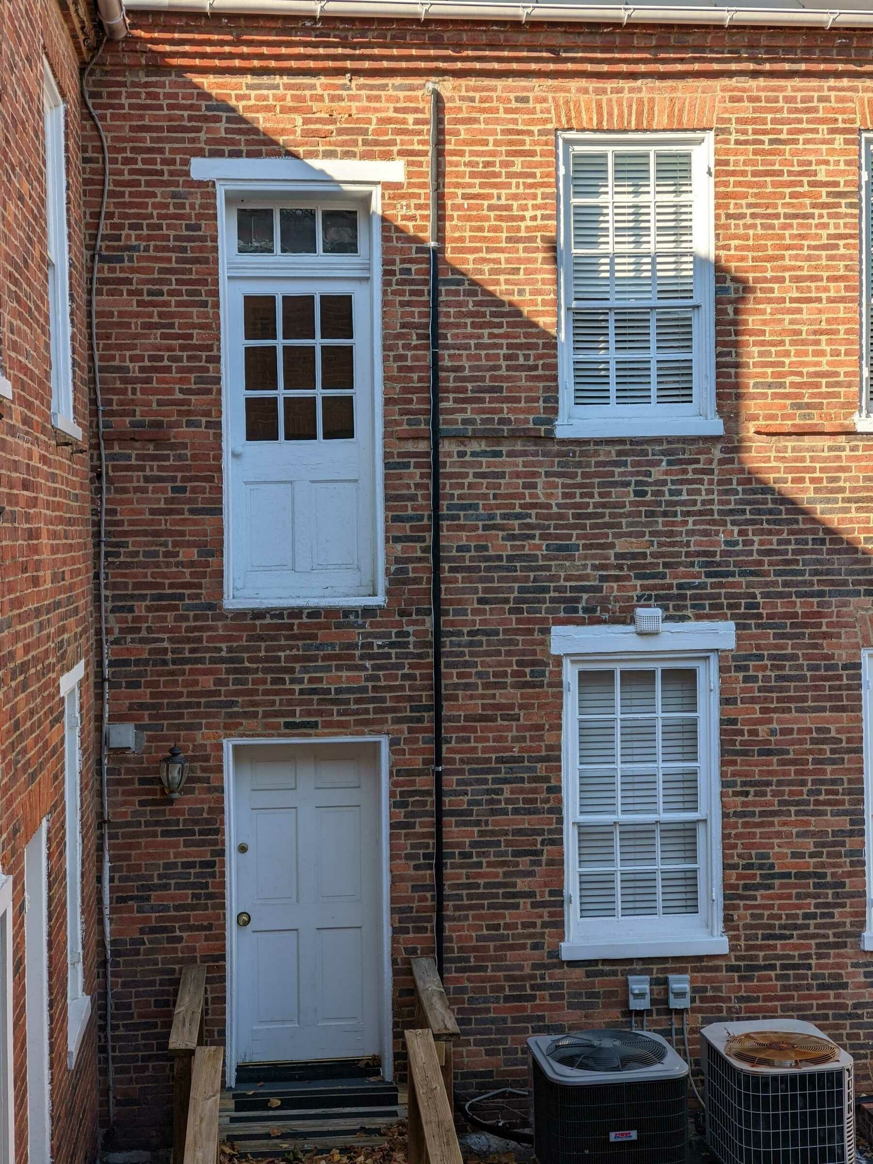on the second story of an old brick building, is a door with no stairwell or balcony attached